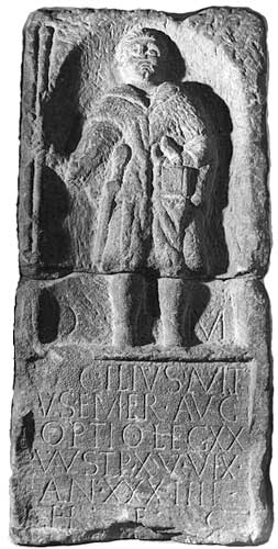 The tombstone of Caecilius Avitus, optio in the XXth legion based at Chester. In his left hand he carries a case of stylus tablets,in his right a a staff.
The inscription reads:

D(is) M(anibus) / Caecilius Avit / us Emer(ita) Aug(usta) / optio leg(ionis) XX / V(aleriae) V(ictricis) st(i)p(endiorum) XV uix(it) / an(nos) XXIIII / h(eres) f(aciendum) c(uravit)

To the spirits of the departed, Caecilius Avitus from Emerita Augusta, optio of the 20th legion Valeria Victrix, of 15 years' service, lived 34 years. His heir had this erected.
