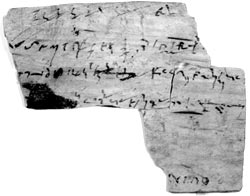 An fragment with several lines of shorthand. At the bottom (upside down) part of a text in capital letters (122)