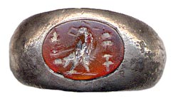 A carnelian intaglio still set in its ring, cut with an image of an eagle with a standard on either side